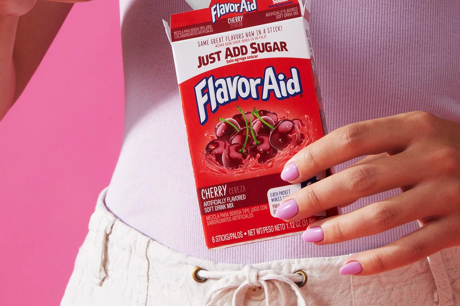 A hand lifting a stick from a Flavor Aid Pitcher Packs carton