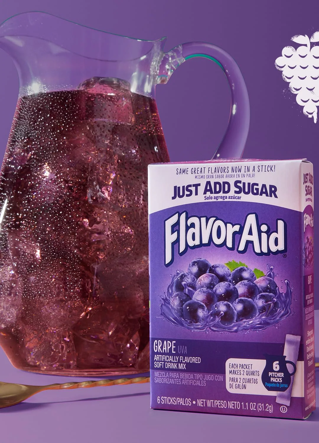 A glass pitcher of purple Flavor Aid Grape over ice beside a Pitcher Packs carton
