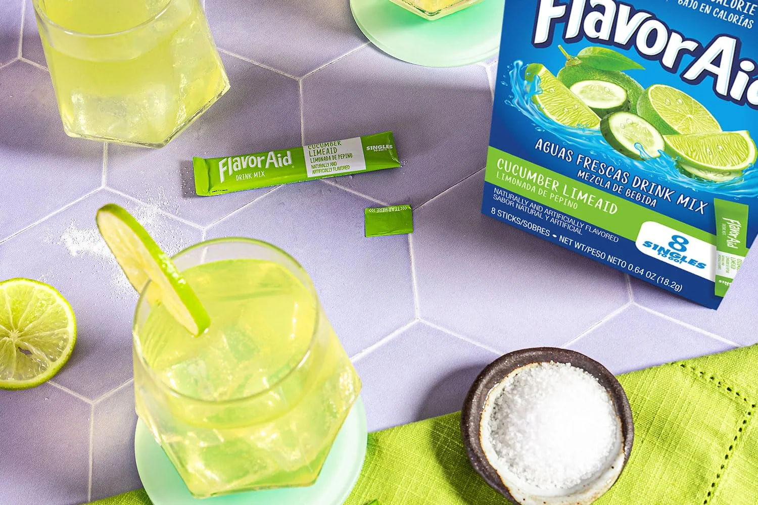 Glasses of Flavor Aid Cucumber Limeaid over ice beside the box