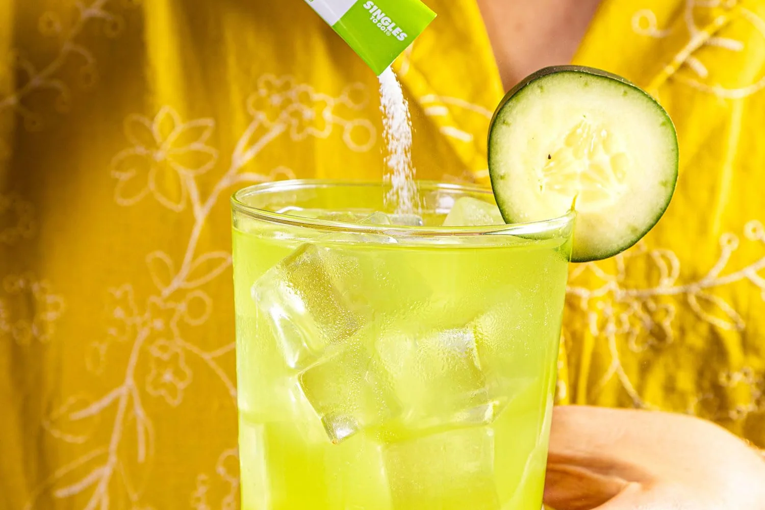 A Flavor Aid Cucumber Limeaid stick poured into a glass of ice water